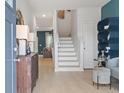 Inviting foyer featuring hardwood floors, modern lighting, neutral paint, and stairway to the second level at 308 Navigator Ln, Mcdonough, GA 30253