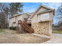 Two-story home with stone accents, wood deck and siding, with sloped driveway at 4962 Preswick Ne Ct, Marietta, GA 30066