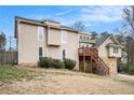 Two-story home with stone accents, wood deck and siding, set against a backdrop of trees at 4962 Preswick Ne Ct, Marietta, GA 30066