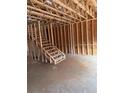 Interior view of a framed house under construction showcasing wooden beams, studs, and a staircase at 4862 Campbell Dr, Atlanta, GA 30349