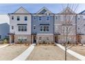 Charming multi-story townhome with brick accents, a well-manicured lawn, and inviting curb appeal at 1258 Ainsworth Aly # 46, Sugar Hill, GA 30518