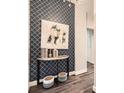 Hallway with wood floors, patterned wallpaper, modern table, and painting at 2626 Peachtree Nw Rd # 804, Atlanta, GA 30305