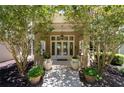 Elegant front entrance with double doors, sidelights, and stylish landscaping at 6995 Polo Fields Pkwy, Cumming, GA 30040