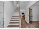 Bright entryway featuring a staircase with wood treads and elegant wood-look floors leading to an open living area at 129 Old Alabama Se Rd, Emerson, GA 30137