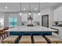 Stylish kitchen featuring a spacious island with seating, pendant lights, white cabinets, and stainless steel appliances at 129 Old Alabama Se Rd, Emerson, GA 30137
