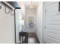Bright hallway with hardwood floors, modern lighting, and a coat rack at 2882 Cadence Walk Rd, Atlanta, GA 30360