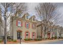 Two-story house featuring brick accents, red shutters, and well-maintained landscaping at 319 Barbados Ln, Suwanee, GA 30024