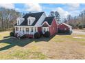 Stunning exterior view of a two-story brick home featuring a welcoming front porch and a detached garage at 1650 Old Loganville Rd, Loganville, GA 30052