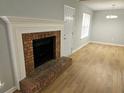 Cozy living room with a brick fireplace, new flooring, and fresh paint at 1666 Hearthstone Way, Jonesboro, GA 30236
