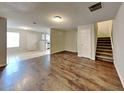 Open-concept living room with hardwood flooring, neutral walls, and access to the staircase and kitchen at 1211 Brookstone Rd, Atlanta, GA 30349