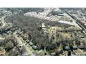 Wide aerial shot featuring lush trees and houses in a quiet neighborhood bordering commercial buildings at 116 Thornton Dr, Jonesboro, GA 30236