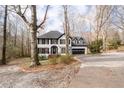 View of home from driveway showing well manicured lawn with mature trees at 2321 Birdie Ln, Duluth, GA 30096