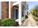 Townhome front door featuring a brick facade and white pillars at 11338 Musette Cir, Alpharetta, GA 30009