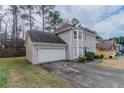 Exterior view of a two-story home with a two-car garage and driveway at 3174 Palm Tree Dr, Lithonia, GA 30038