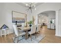 Elegant dining room with modern light fixture and views into the living room at 7438 Jennadee Dr, Fairburn, GA 30213