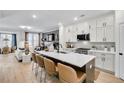 Open-concept kitchen boasts a large island, white cabinets, and seamless flow to the living area at 220 Village Overlook # K2, Canton, GA 30114
