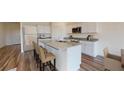 Kitchen with granite counters, island with bar seating, and stainless steel appliances at 7717 Sudbury Cir, Covington, GA 30014