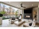 A luxurious covered patio with a modern fireplace, mounted TV, and comfortable seating overlooking the beautiful backyard pool at 185 Pebble Trl, Alpharetta, GA 30009