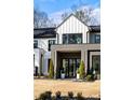 Modern farmhouse exterior with black trim, manicured lawn, and statement lighting, showcasing the home's striking curb appeal at 185 Pebble Trl, Alpharetta, GA 30009