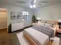 This staged bedroom features neutral decor, a window, and a ceiling fan at 6090 Wintergreen Rd # 1A3, Norcross, GA 30093