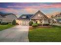 Charming home featuring a manicured lawn, two-car garage, and inviting curb appeal at sunset at 164 Owens Farm Ln, Woodstock, GA 30188