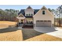 Charming two-story home with a covered front porch, attached garage, and neutral siding at 1721 Mcgarity Rd, Temple, GA 30179