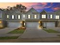 Townhomes with mixed exteriors of stone and siding, complemented by landscaped lawns, under a colorful twilight sky at 3848 Pressley Ln # 26, Powder Springs, GA 30127