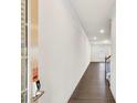 Inviting hallway with dark wood floors, white walls and trim, leading to a bright window at the end at 3848 Pressley Ln # 26, Powder Springs, GA 30127