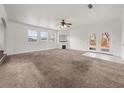 Bright living room with carpet, built-in shelves, fireplace, and French doors leading to the backyard at 57 Pierce Rd, Hiram, GA 30141