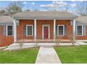 Inviting brick porch with white columns, contrasting shutters, and well-kept lawn at 3113 Melissa Ct, Douglasville, GA 30135