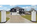Beautiful two-story home with manicured front lawn, concrete driveway, and stately brick entrance pillars at 557 Loth Wages Rd, Dacula, GA 30019
