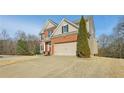 Exterior elevation showing a 2-story brick and tan home with an attached 2-car garage at 5305 Redfield Way, Cumming, GA 30028