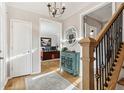 A foyer showcasing hardwood floors, staircase with metal spindles, decorative cabinet and open office space at 5305 Redfield Way, Cumming, GA 30028