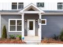 Close up of the front porch with white trim, a storm door, and black exterior sconces at 1467 Lockwood Sw Dr, Atlanta, GA 30311