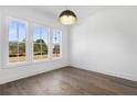 Bright room with hardwood floors, large windows, and a stylish pendant light at 3909 Enclave Way, Tucker, GA 30084