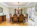 Elegant dining room with hardwood floors, a bay window, and crown molding at 445 Edenbrooke Way, Roswell, GA 30075