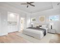 A luxurious main bedroom featuring a tray ceiling, hardwood floors, and a built-in vanity at 1010 Coleman Place Dr, Roswell, GA 30075