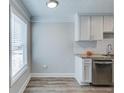 Bright kitchenette features white cabinets, stainless steel appliances, and granite countertops at 2340 Beaver Ruin Rd # Un62, Norcross, GA 30071