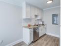 Bright kitchenette features white cabinets, stainless steel appliances, and granite countertops at 2340 Beaver Ruin Rd # Un62, Norcross, GA 30071