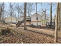 View of the back of the house from the far side of the wooded yard at 5303 Martins Crossing Rd, Stone Mountain, GA 30088