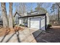 Angle view of a white home with black trim and an attached one-car garage at 5303 Martins Crossing Rd, Stone Mountain, GA 30088