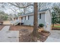 Side view of a single-story home with a small partial basement garage and landscaped yard at 112 Oakland Blvd, Stockbridge, GA 30281