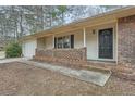 Cozy front porch with brick railing, leading to a black front door with a storm door, and an attached garage at 2102 Red Berry Sw Ln, Marietta, GA 30008