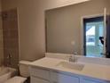 Bathroom with a large mirror, white vanity, and tiled shower over the tub at 452 Eagles Nest Cir, Auburn, GA 30011