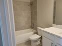 Tiled bathroom features a shower over the tub and a white vanity with grey floor tiles at 452 Eagles Nest Cir, Auburn, GA 30011