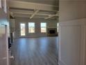 Open-concept living room featuring a brick fireplace, coffered ceilings, and light gray laminate flooring at 452 Eagles Nest Cir, Auburn, GA 30011