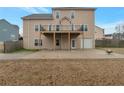 Exterior view of home with a balcony overlooking a concrete patio and large yard at 726 Fraser Ct, Mcdonough, GA 30253