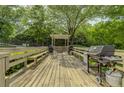 Spacious outdoor grilling area with multiple stations on a wood deck surrounded by trees at 1501 Clairmont Rd # 1318, Decatur, GA 30033