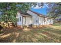 Cozy single-story home with white siding and a fenced-in yard, surrounded by mature trees, giving a sense of privacy at 3581 Midway Rd, Decatur, GA 30032