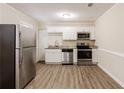 Updated kitchen featuring stainless steel appliances, granite counters, and white cabinets at 8673 Chestnut Ln, Lithia Springs, GA 30122